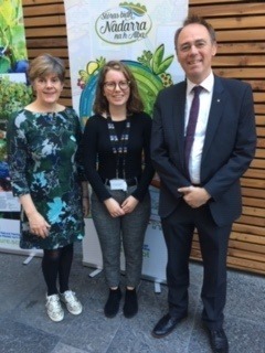 Picture: Three people standing in front of a banner with Gaelic writing on it