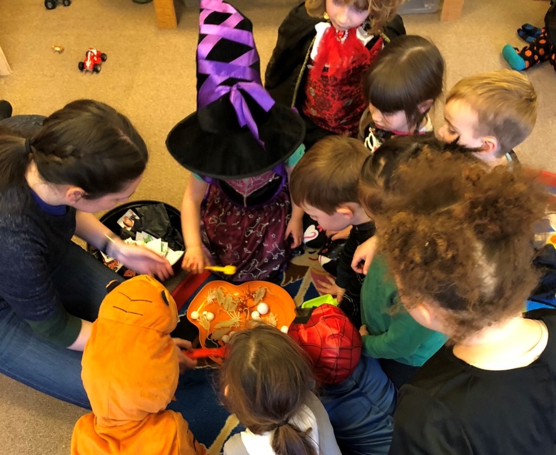 Picture : Children's halloween party looking at spooky things in an orange bowl.