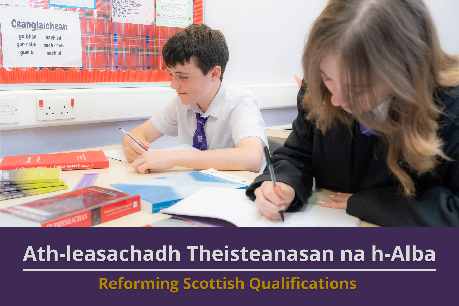 Picture: A high school aged boy and girl working at their desk in a classroom with textbooks infront of them. Text reads 'Reforming Scottish Qualifications'