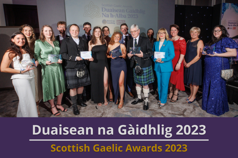 Picture: 2023 Scottish Gaelic Awards winners posing together with their awards. Text reads 'Scottish Gaelic Awards 2023'