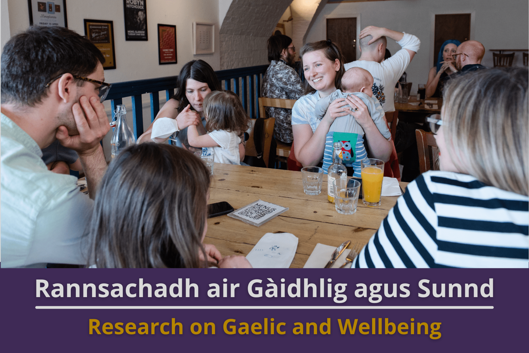 Picture: Gaelic meet-up in a cafe in Glasow where people of all ages are sitting round the tables, chatting and smiling. Text reads 'Research on Gaelic and Wellbeing'